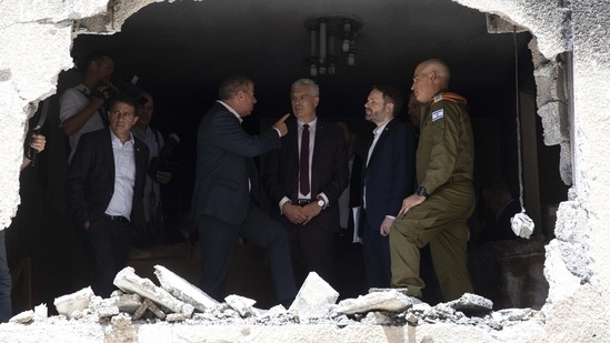 Israeli Foreign Minister Gabi Ashkenazi (2L), Slovakia's Foreign Minister Ivan Korcok (C) and Czech Foreign Minister Jakub Kulhanek (2R), visit the site of a rocket attack in Petah Tikvah, Israel, on May 20. In Israel, 12 people were killed and hundreds treated for injuries in rocket attacks that caused panic and sent people rushing into shelters, Reuters reported.(Sebastian Scheiner / AP)