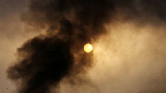Smoke rises from a factory hit by Israeli shells in the recent cross-border violence, at sunrise in Gaza on May 21. Mosque loudspeakers feted "the victory of the resistance achieved over the Occupation (Israel)," Reuters reported.(Ibraheem Abu Mustafa / REUTERS)