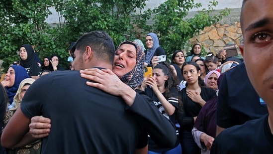 Mourners react during the funeral of Mohammad Kiwan, a 17-year-old Palestinian who succumbed to his wounds after being shot during confrontations with Israeli troops last week, in Umm al-Fahm, Israel, on May 20. Both Israel and Hamas said it was ready to retaliate for any truce violations by the other. Egypt said it would send two delegations to monitor the ceasefire it had mediated, Reuters reported.(Ahmad Gharabli / AFP)