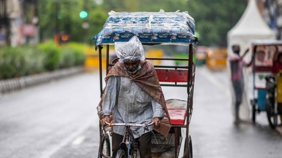 A rickshaw driver looks for passengers along a street under a light rain shower in New Delhi on May 21, 2021. (AFP Photo) A rickshaw driver looks for passengers along a street under a light rain shower in New Delhi on May 21, 2021. (AFP Photo)