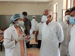 Hemaram Choudhary (R) speaks to a doctor at a healthcare centre in Rajasthan,