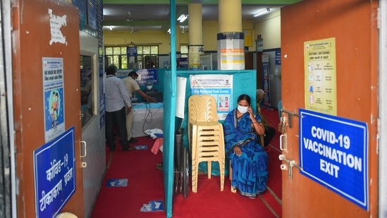 A beneficiary speaks on her phone while waiting during a Covid-19 vaccination drive at SDMC Urban Public Health Centre in Daryaganj, New Delhi on May 22. Delhi has run out of coronavirus vaccines for adults below the age of 45, the Delhi government said on May 21, announcing that centres catering to this age group will be shut from May 22 with no new stocks expected for the rest of the month, HT reported.(Shahbaz Khan / PTI)
