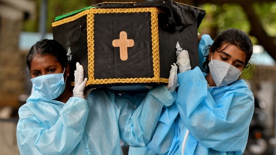 Volunteers carry the body of a person who died from the coronavirus disease (Covid-19) for burial at a cemetery in Bengaluru, India, May 18, 2021. (Reuters)