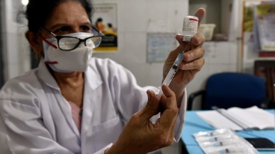 A health worker prepares a dose of a Covid-19 vaccine at the SDMC Dispensary in Nehru Nagar, New Delhi on May 18. Delhi on May 21 hit an important landmark, administering over 5 million vaccine doses – including first and second shots – since the exercise began on January 16, HT reported.(Sanjeev Verma / HT Photo)