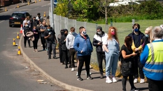 People queue to receive Covid-19 vaccinations at the ESSA Academy in Bolton, England. (AP) People queue to receive Covid-19 vaccinations at the ESSA Academy in Bolton, England. (AP)