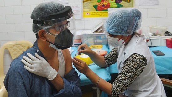 A health worker inoculates a man with a dose of the Covid-19 vaccine at SDMC Urban Public Health Centre in Daryaganj, New Delhi on May 22. To be sure, Delhi has doses for people aged 45 and above, and private hospitals are carrying out vaccinations for the under-45 age group from stocks directly procured from the manufacturers.(Shahbaz Khan / PTI)