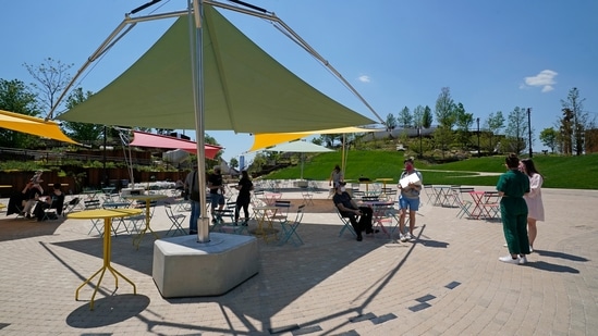 Workers and staff move about in an outdoor dining area at Little Island, a park along the Hudson River, Tuesday, May 18, 2021, in New York, ahead of the park's planned public opening Friday. (AP)