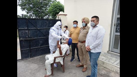 A health workers collects swab sample of an elderly man at Dhablan village in Patiala district. A health workers collects swab sample of an elderly man at Dhablan village in Patiala district.