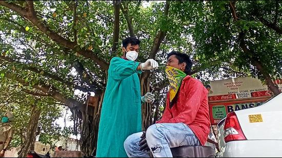 A health worker collecting a swab sample during a special testing camp for labourers at Industrial Area, Phase 1, in Chandigarh, on Saturday. (Ravi Kumar/HT) A health worker collecting a swab sample during a special testing camp for labourers at Industrial Area, Phase 1, in Chandigarh, on Saturday. (Ravi Kumar/HT)