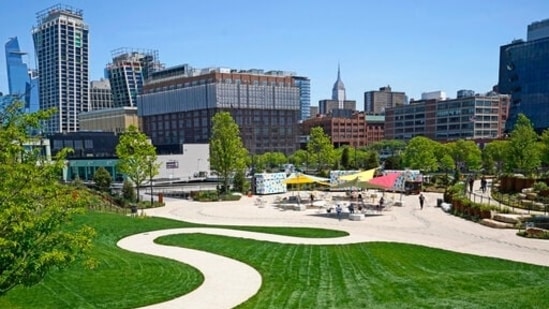 The Empire State Building can be seen from a distance from a winding path that leads to a casual outdoor dining area, Tuesday, May 18, 2021, at Little Island, in New York. Located atop Hudson River piers damaged during Superstorm Sandy, the park features two amphitheaters, a playground, winding paths and staircases, and views of the city from multiple angles. (AP)