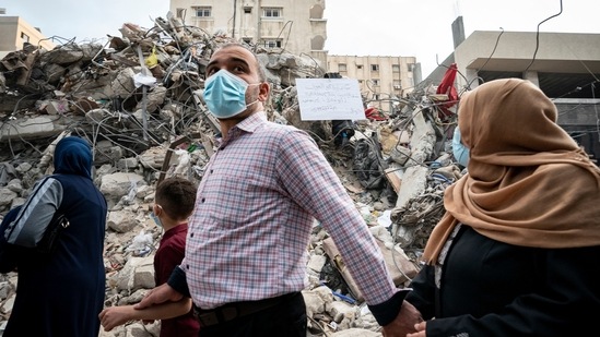 A family passes the rubble from a building previously destroyed in an air-strike following a cease-fire reached after an 11-day war between Gaza's Hamas rulers and Israel, in Gaza City, (AP) A family passes the rubble from a building previously destroyed in an air-strike following a cease-fire reached after an 11-day war between Gaza's Hamas rulers and Israel, in Gaza City, (AP)
