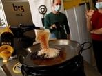 Chef Maria Munoz watches as a robot created by Spanish companies br5 and Mimcook makes paella during a demonstration at a warehouse in San Fernando de Henares, outside Madrid, Spain, May 20, 2021. 