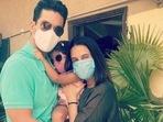 Neha Dhupia and Angad Bedi pose with their daughter.