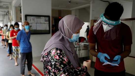 In recent weeks, the government has conducted special testing operations for clusters that broke out at airports, shopping malls and schools. In picture - Residents of a public housing estate queue up for mandatory Covid-19 tests in Singapore. (Reuters)