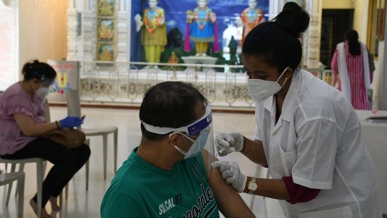 A medic inoculates the dose of the COVID-19 vaccine a beneficiary, at Swaminarayan Temple in Mumbai. (ANI Photo)