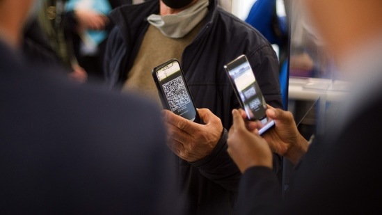 A traveler, center, uses the 'TousAntiCovid' Coronavirus tracing smartphone app to board an Air France-KLM flight, at the departure gates at Orly Airport, operated by Aeroports de Paris, in Paris, France. (Bloomberg) A traveler, center, uses the 'TousAntiCovid' Coronavirus tracing smartphone app to board an Air France-KLM flight, at the departure gates at Orly Airport, operated by Aeroports de Paris, in Paris, France. (Bloomberg)