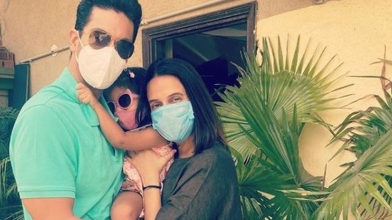 Neha Dhupia and Angad Bedi pose with their daughter.