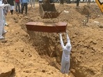 An employee of Michael Undertakers and Ambulance Services wearing PPE suit, lays a coffin to rest during the burial of a Covid-19 victim at a Christian cemetery in Pali village near Faridabad on May 8. According to the Union ministry of health and family welfare (MoHFW) dashboard on May 24 morning, India registered 4,454 Covid-19 related deaths in the last 24 hours, taking the death toll to 303,720.