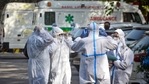 Family members of a Covid-19 victim in PPE coveralls waiting outside a cremation ground, in Punjabi Bagh, New Delhi, India, on Monday, May 24, 2021. (Photo by Sanchit Khanna/ Hindustan Times)