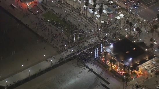 People gathered at the Huntington Beach pier in Huntington Beach, California Police in Huntington Beach. (AP) People gathered at the Huntington Beach pier in Huntington Beach, California Police in Huntington Beach. (AP)