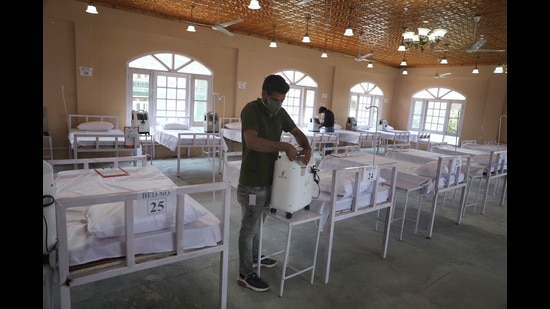 Medical workers checking equipment at a marriage hall, which has been converted into a Covid wellness centre, in Srinagar on Monday. (WASEEM ANDRABI/HT) Medical workers checking equipment at a marriage hall, which has been converted into a Covid wellness centre, in Srinagar on Monday. (WASEEM ANDRABI/HT)