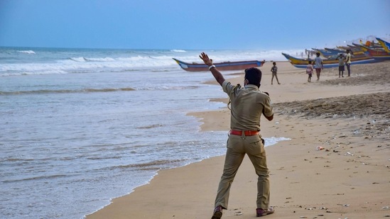 A police person announces cyclone related warnings at a beach in Puri. (PTI) A police person announces cyclone related warnings at a beach in Puri. (PTI)