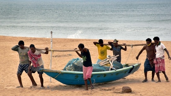 Fishermen carry a boat to a safe place ahead of Cyclone Yaas at Puri beach in Odisha. (PTI Photo) Fishermen carry a boat to a safe place ahead of Cyclone Yaas at Puri beach in Odisha. (PTI Photo)