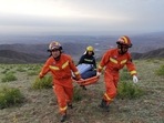 Rescue workers carry a stretcher as they work at the site where extreme cold weather killed participants of a 100-km ultramarathon race in China(VIA REUTERS)