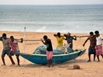 Fishermen carry a boat to a safe place ahead of Cyclone Yaas at Puri beach in Odisha.
