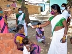 A health worker conducts thermal screening of a villager during a COVID-19 awareness drive at Mahilong Panchayat near Ranchi,