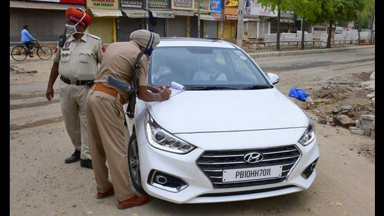 Police issuing a challan to a lockdown violators at Malhar Road in Ludhiana. (Harsimar Pal Singh/HT)