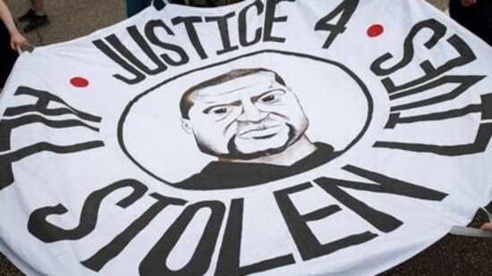 People hold a banner at a rally and march organized by families who were victims of police brutality for the one year anniversary of George Floyd's death on May 24, 2021. (AP) People hold a banner at a rally and march organized by families who were victims of police brutality for the one year anniversary of George Floyd's death on May 24, 2021. (AP)