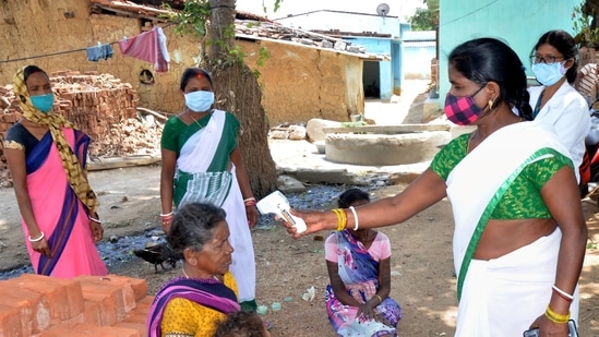 A health worker conducts thermal screening of a villager during a COVID-19 awareness drive at Mahilong Panchayat near Ranchi, (PTI) A health worker conducts thermal screening of a villager during a COVID-19 awareness drive at Mahilong Panchayat near Ranchi, (PTI)