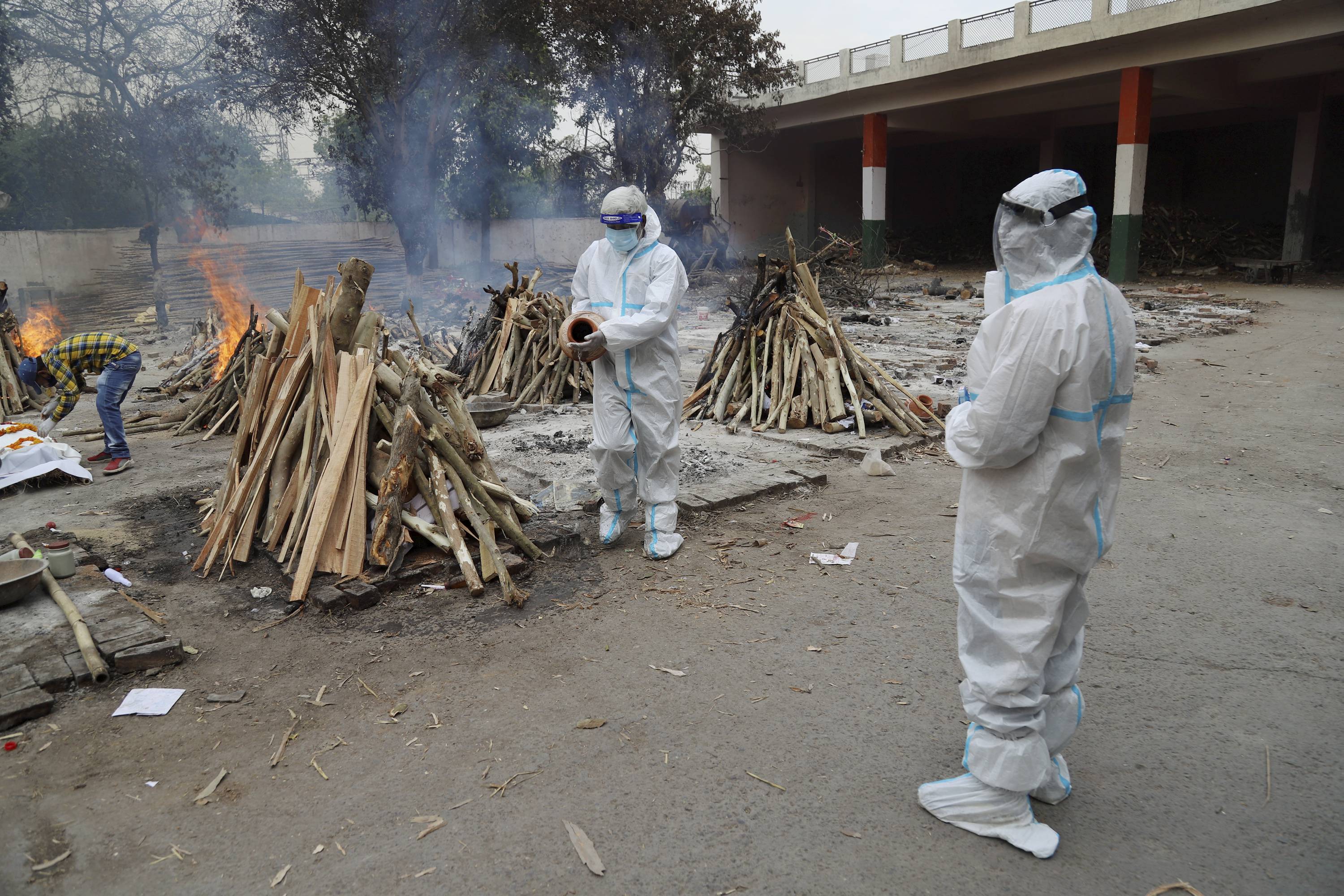 Relatives wearing PPE kits cremate bodies of Covid-19 victims, at the Ghazipur crematorium in New Delhi, Tuesday, May 4, 2021. (PTI) Relatives wearing PPE kits cremate bodies of Covid-19 victims, at the Ghazipur crematorium in New Delhi, Tuesday, May 4, 2021. (PTI)