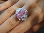 An employee poses with a 15.81 carat fancy vivid purple pink diamond ring, which is called The Sakura Diamond, during a preview at Christie’s.
