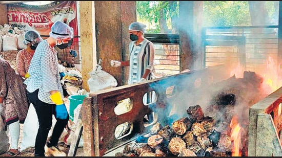 Women volunteers at the Vaikunth crematorium collect wood and dung cakes to prepare the pyre before the bodies arrive. (HT PHOTO) Women volunteers at the Vaikunth crematorium collect wood and dung cakes to prepare the pyre before the bodies arrive. (HT PHOTO)