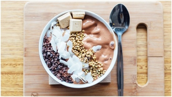 Chocolate smoothie bowl: Blend 2 frozen bananas, 1/3 cup almond milk, 2 dates, 1 1/2 tablespoon peanut butter, 2 tablespoon cacao/cocoa powder. While serving top it with chia seeds, granola, shredded coconut and half a banana.(Unsplash)