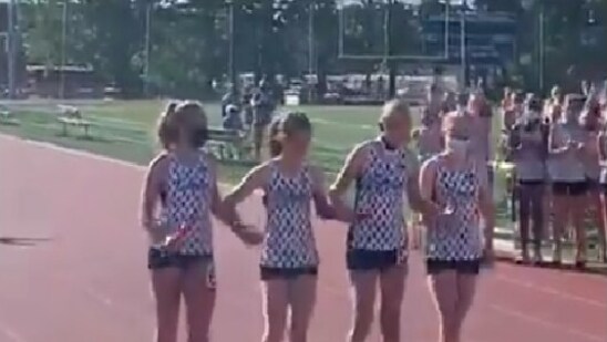 The image shows three teammates of Yeva Klingbeil, a cancer warrior, helping her get across the line in a relay race.(Twitter@ShenAthletics)