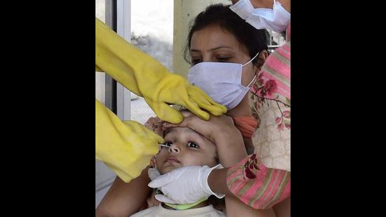 A health worker collecting swab samples of a child for Covid testing in Ludhiana on Thursday. (Gurpreet Singh/HT) A health worker collecting swab samples of a child for Covid testing in Ludhiana on Thursday. (Gurpreet Singh/HT)