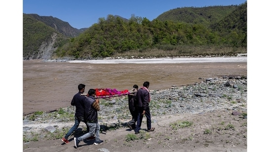 Relatives of Pramila Devi carrying her body to be cremated on the banks of the river Ganga, in Pauri Garhwal on May 24. The 36-year-old mother-of-three died the previous night in a village in the Uttarakhand, a day after testing positive for Covid-19.(Danish Siddiqui / REUTERS)