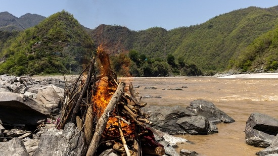 Pramila Devi being cremated on the banks of the river Ganga, in Pauri Garhwal on May 24. Pauri Garhwal district - where Devi's family lives - has reported 5,155 Covid-19 cases and 241 deaths. But locals and doctors told Reuters, that many in the district suffering Covid-like symptoms refuse to get tested or test too late.(Danish Siddiqui / REUTERS)