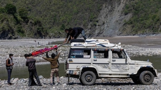 Relatives unloading Pramila Devi's body from a jeep before her cremation, in Pauri Garhwal on May 24. Devi's death is a sign of how fear and a lack of facilities are adding to Covid-19 fatalities in remote villages, where many shun tests for fear of testing positive and being forced to go to a hospital far from home, Reuters reported.(Danish Siddiqui / REUTERS)