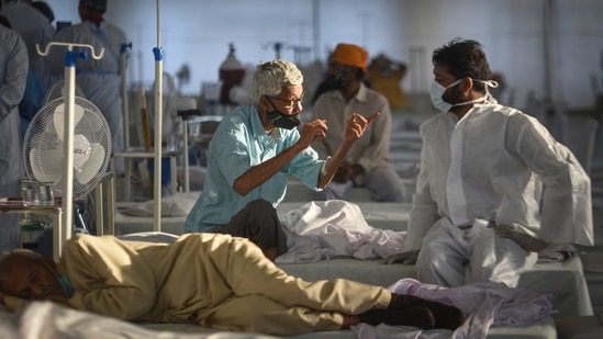 Doctors tend to a patient at the Covid-19 care centre at Rakabganj gurdwara. (Sanchit Khanna/HT PHOTO)
