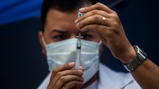 A health worker prepares a shot of the AstraZeneca vaccine for COVID-19 at a public square during a vaccination program for the homeless in Rio de Janeiro, Brazil, Thursday, May 27, 2021. (AP)