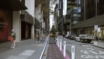 Fußgänger gehen während einer Sperrung in Melbourne, Australien, eine fast menschenleere Straße entlang.  (Blümberg)