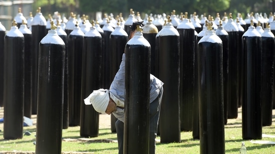 A worker paints oxygen cylinders at Common Wealth Games Village in New Delhi, on May 24. Thursday’s case count, the lowest in a single-day since March 30 (when it added 992 cases) came on the back of over 70,000 tests, and at a positivity rate of 1.53%, a number that has now dropped for 21 consecutive days, HT reported.(Atul Yadav / PTI)