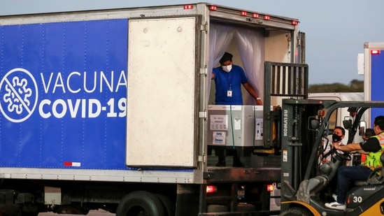 Containers of AstraZeneca vaccines under the Covax scheme are loaded onto a truck after arriving at an airport, in San Luis Talpa, El Salvador.(Reuters)