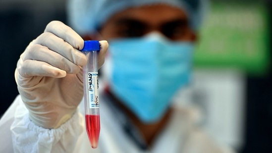 A health worker holds up a preserved swab sample at a Covid-19 testing centre in Kalkaji, New Delhi, on May 27. The positivity rate in Delhi has now stayed below 5% for a week, and below 2% for two days.(Sanjeev Verma / HT Photo)