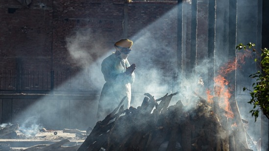 Jitender Shanti of Bhagat Singh Seva Dal performs the last rites of an unclaimed body at Seemapuri cremation ground in New Delhi, on May 24. 117 people succumbed to Covid-19 on May 27. The seven-day average deaths fell to 176, the lowest since April 20, HT reported.(Atul Yadav / PTI)