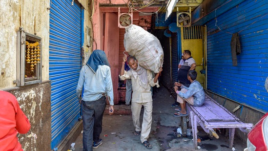 A worker carries a sack on his shoulder, at Khari Baowli in New Delhi, on May 25. Delhi chief minister Arvind Kejriwal on May 28 announced that the construction sector in the city and factories can resume operations from May 31.(Vijay Verma / PTI)
